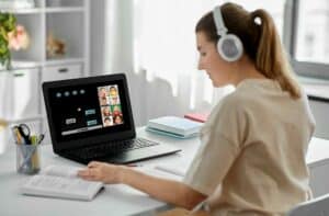 Frau lernt online mit Laptop und Kopfhörern
