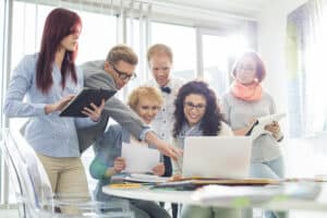 Team arbeitet gemeinsam am Laptop im Büro