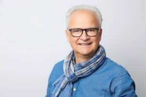 Mann mit Brille und Schal lächelt