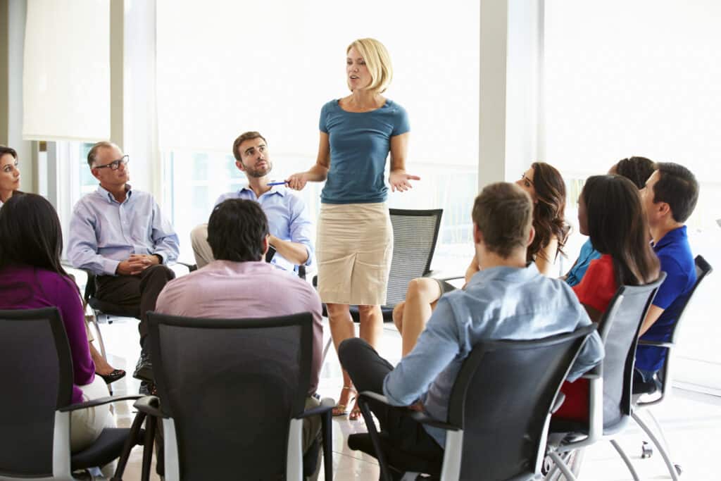 Frau präsentiert vor Team im Büro