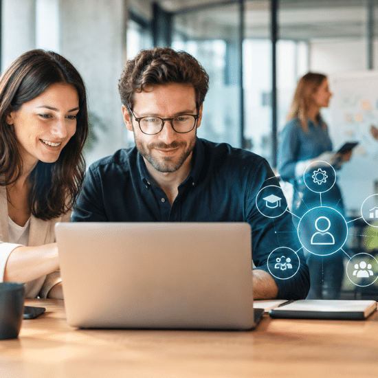 Zwei Kollegen arbeiten am Laptop mit HR-Symbolen